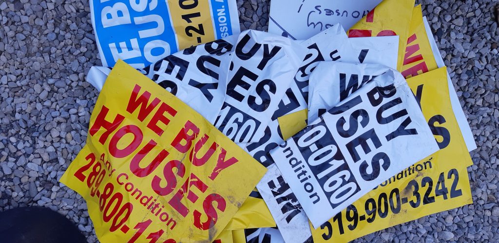 A pile of illegal signs collected from roadsides in Kitchener advertising business services