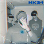 HK24 (B&W photo of three men, man in th eforeground wearing a bandana around his forehead shields his eyes from the camera; two men in the background have their eyes barred over to hide their identities)