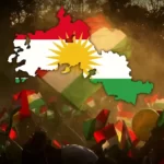Outline of a map of Kurdistan coloured in the colours of the Kurdish flag on a background of people protesting and waving Kurdish flags)