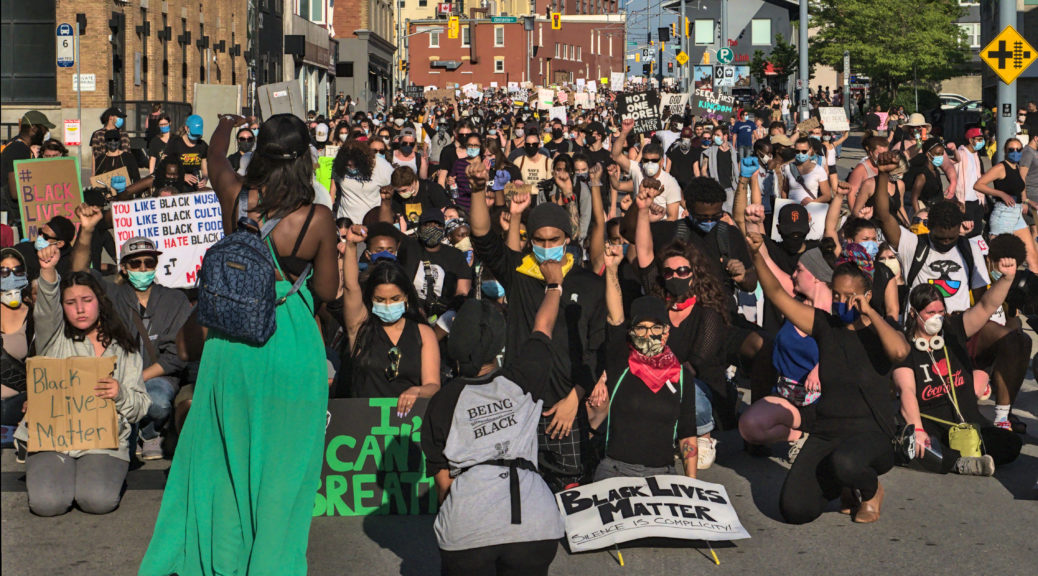 Thousands of people kneel with their fists raised at the Black Lives Matter march in Kitchener on June 3rd 2020