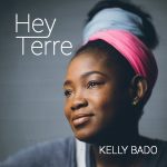 Hey Terre | Kelly Bado (a woman with her hair up, wrapped in pink and blue scarves)