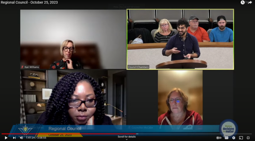 A screenshot from the webcast of the October 25th Waterloo Region Council meeting. In the image, Sam Nabi is delegating to council while standing at a podium. Nabi is smiling as he answers a question from Councilor McCabe, The screen shot also includes the video feeds from councilors, Williams, James, and McCabe