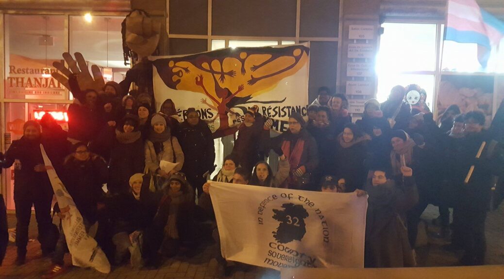 Workers, clients, and supporters of the International Workers' Centre in Montreal are standing in front of the office.